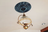 Marble-patterned medallion displayed around an elegant light fixture. 