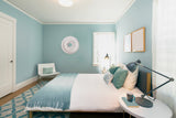 White medallion displayed in a clean, blue bedroom.